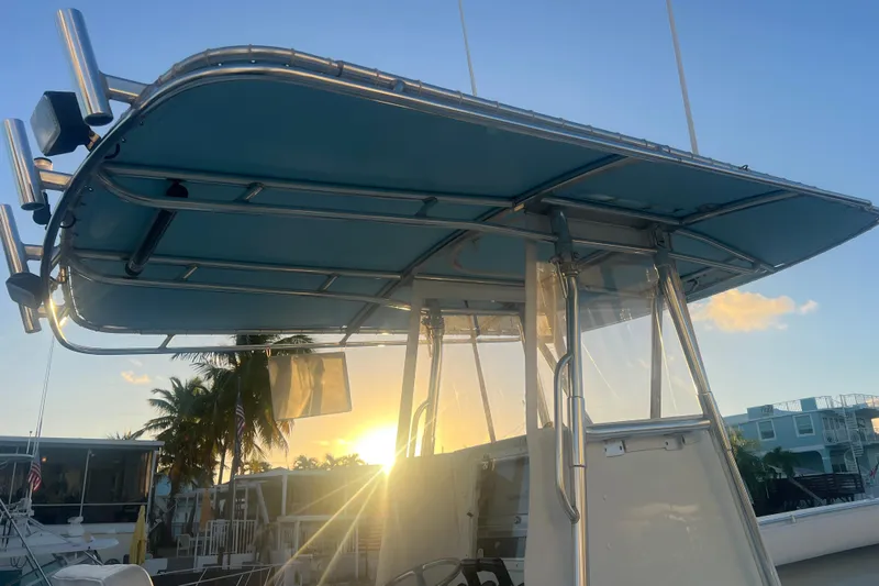  Yacht Photos Pics 2003 Contender 27 Open boat with T-top at sunset, docked near palm trees.
