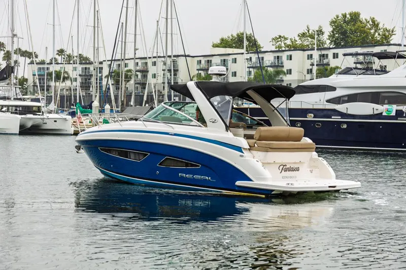 Fantasea Yacht Photos Pics 2014 Regal 32 Express boat docked in marina, surrounded by sailboats and buildings.