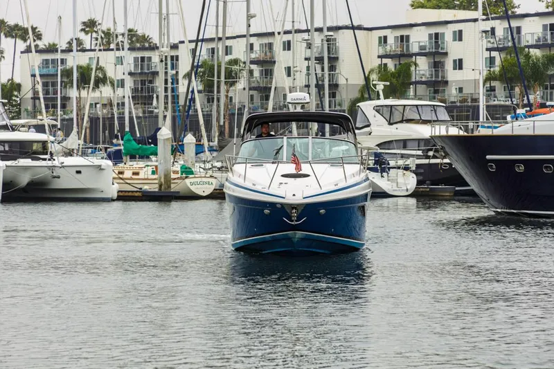 Fantasea Yacht Photos Pics 2014 Regal 32 Express boat navigating a marina, surrounded by sailboats and yachts.