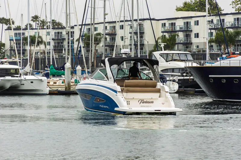 Fantasea Yacht Photos Pics 2014 Regal 32 Express boat navigating marina with yachts and waterfront buildings.