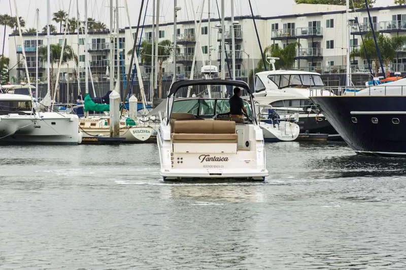 Fantasea Yacht Photos Pics 2014 Regal 32 Express boat navigating marina with yachts and waterfront buildings.