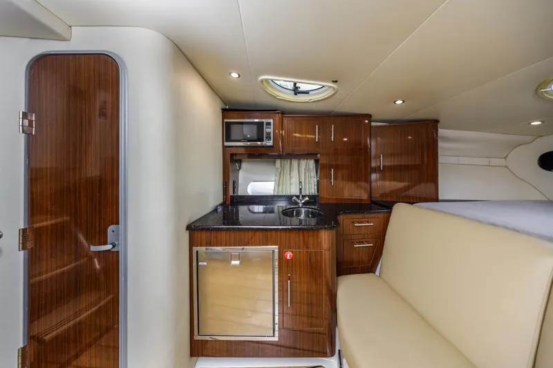 Fantasea Yacht Photos Pics 2014 Regal 32 Express yacht interior with kitchenette, featuring wood cabinets and modern appliances.