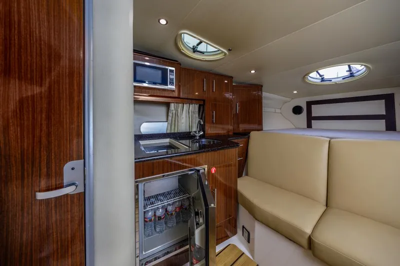 Fantasea Yacht Photos Pics 2014 Regal 32 Express yacht interior with kitchenette, fridge, and seating area.