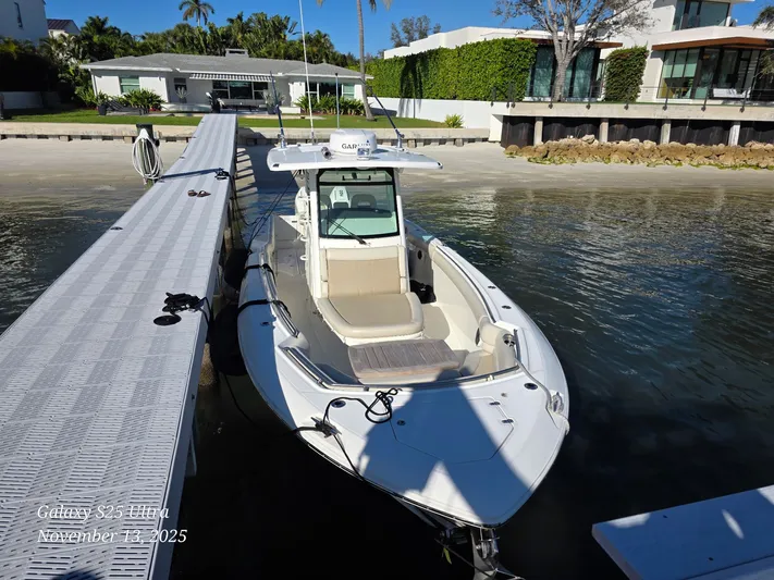  Yacht Photos Pics 2022 Boston Whaler 330 Outrage docked by a modern waterfront home.