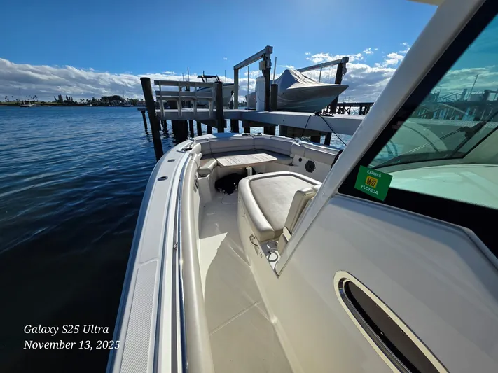  Yacht Photos Pics Boston Whaler 330 Outrage 2022 docked by a pier under a clear blue sky.