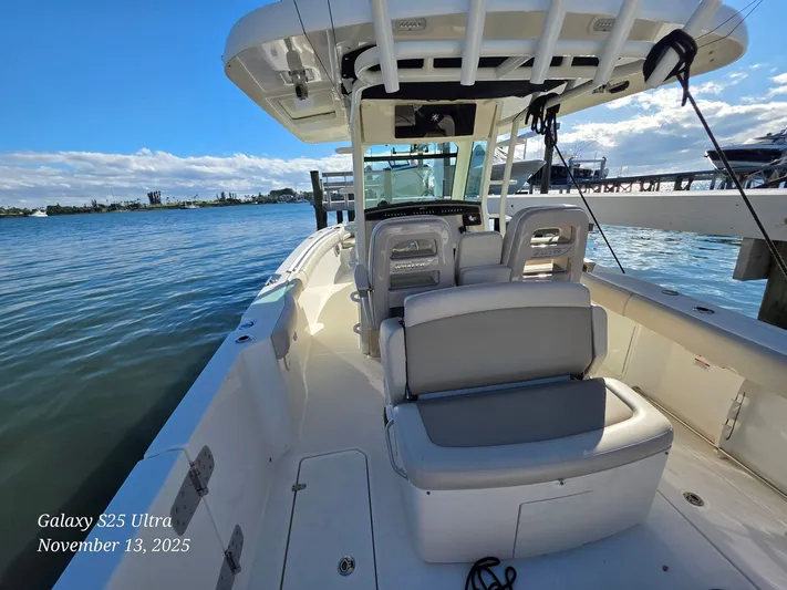 Yacht Photos Pics 2022 Boston Whaler 330 Outrage boat docked on a sunny day, showcasing spacious seating.