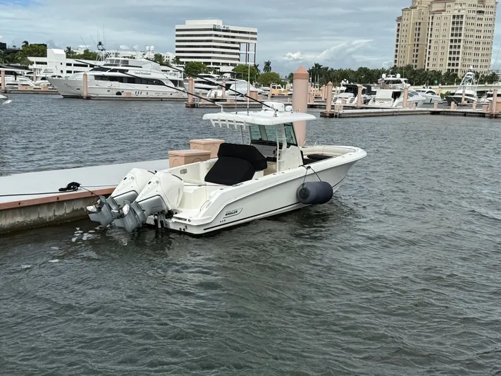  Yacht Photos Pics 2022 Boston Whaler 330 Outrage docked at a marina with luxury yachts.