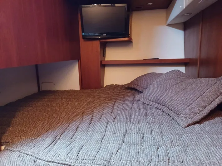  Yacht Photos Pics Cozy cabin interior of 2002 Tiara Yachts 4000 Express with bed and mounted TV.