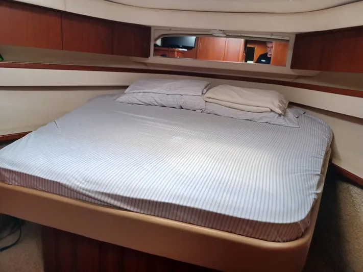  Yacht Photos Pics Cozy bedroom in 2002 Tiara Yachts 4000 Express with striped bedding and wooden accents.
