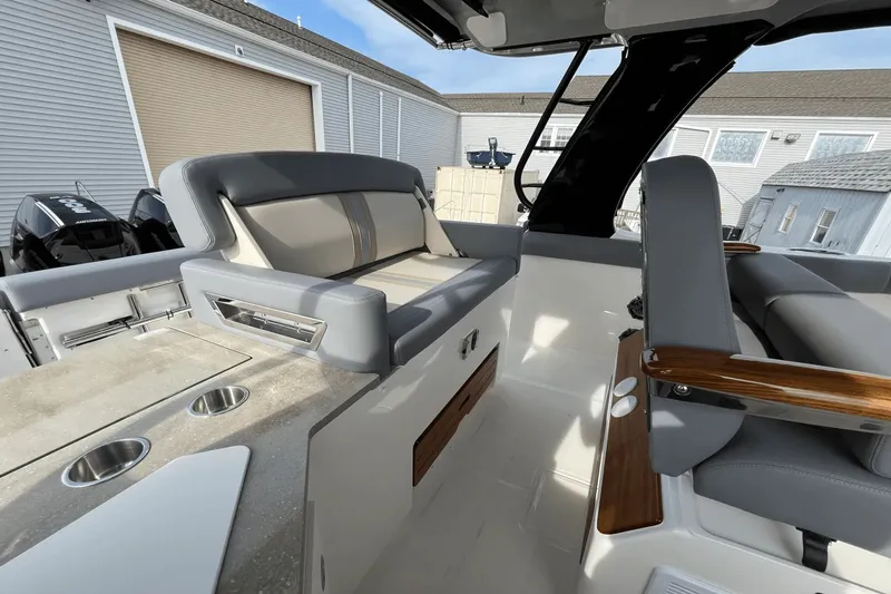  Yacht Photos Pics 2025 Boston Whaler 350 Realm interior with seating and cup holders, showcasing luxury design.