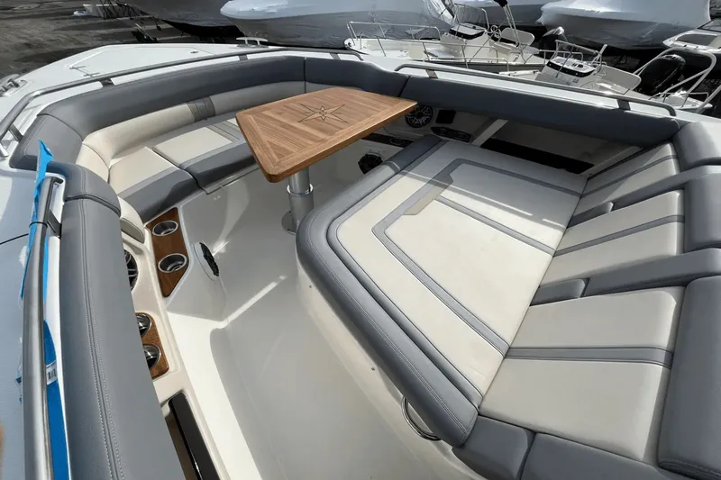  Yacht Photos Pics Luxurious seating area on 2025 Boston Whaler 350 Realm with elegant wooden table.