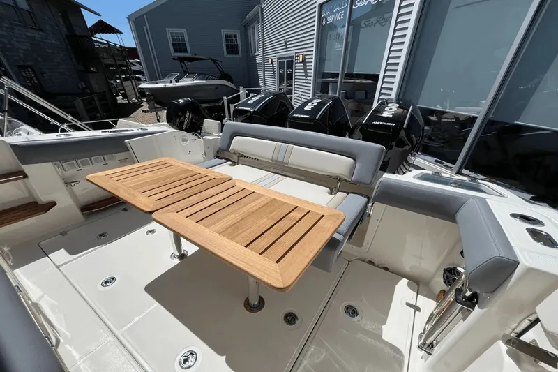  Yacht Photos Pics 2025 Boston Whaler 350 Realm boat interior with wooden table and seating.