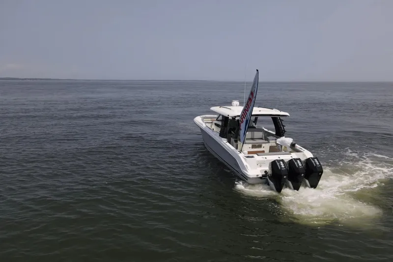  Yacht Photos Pics 2025 Boston Whaler 350 Realm cruising on open water, showcasing triple outboard engines.