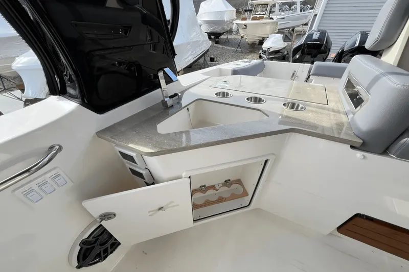  Yacht Photos Pics 2025 Boston Whaler 350 Realm boat interior with sink, storage, and seating area.