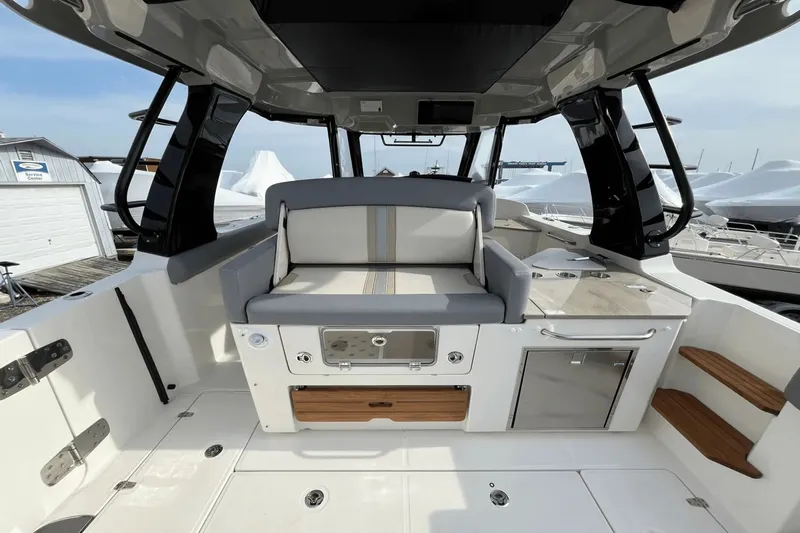  Yacht Photos Pics 2025 Boston Whaler 350 Realm interior with seating, kitchenette, and storage.