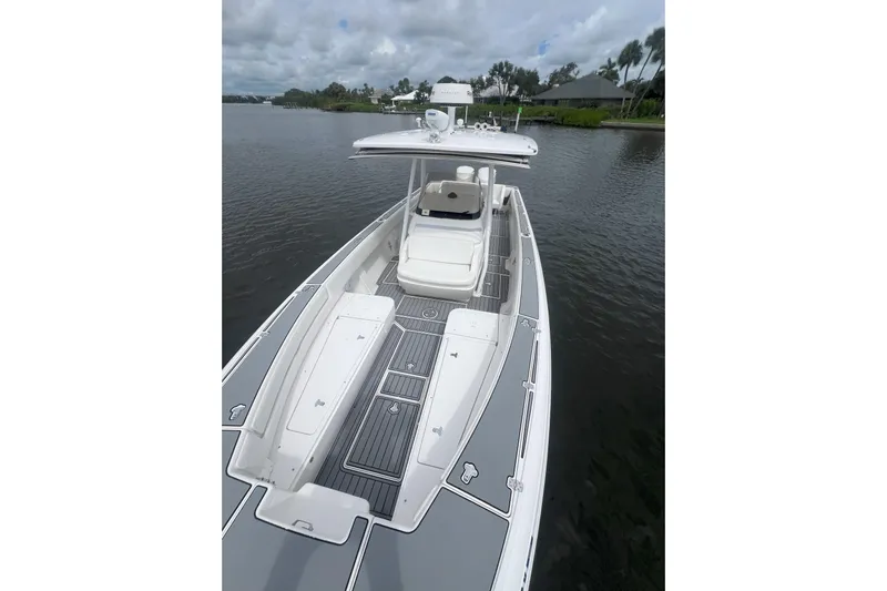  Yacht Photos Pics 2011 Intrepid 323 Cuddy boat on calm water, featuring sleek design and spacious deck.