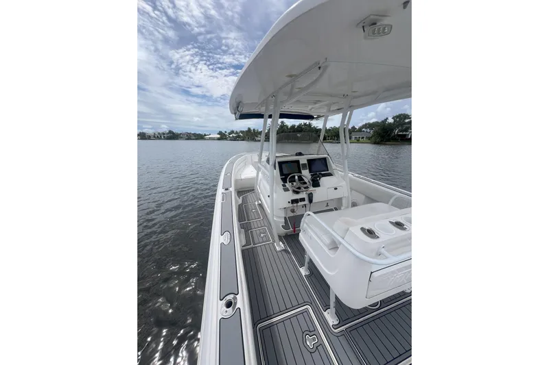  Yacht Photos Pics 2011 Intrepid 323 Cuddy boat on calm water, featuring sleek design and modern cockpit.