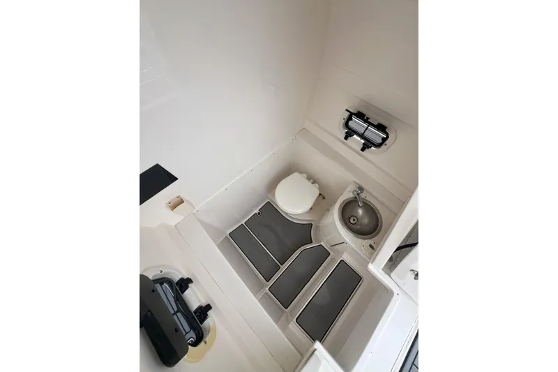  Yacht Photos Pics Interior of a 2011 Intrepid 323 Cuddy boat featuring a compact bathroom with toilet and sink.