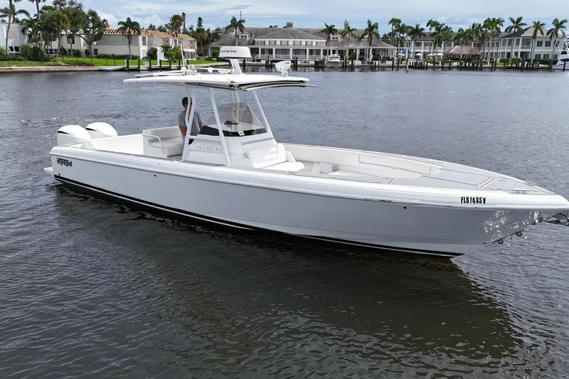  Yacht Photos Pics 2011 Intrepid 323 Cuddy boat on calm water, near waterfront homes.