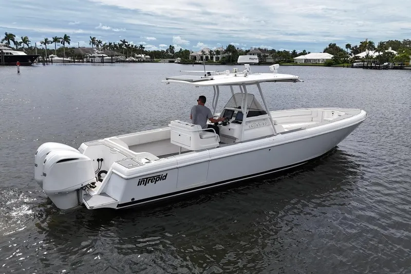  Yacht Photos Pics 2011 Intrepid 323 Cuddy boat cruising on a calm waterway, featuring twin engines.