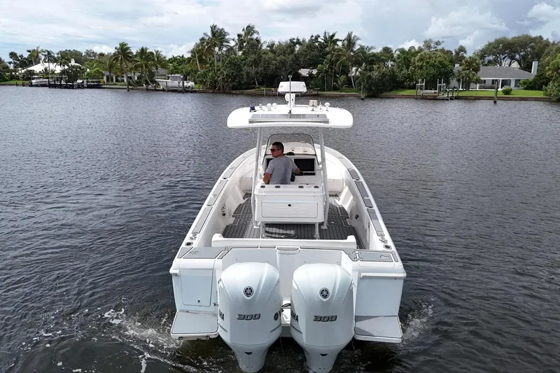  Yacht Photos Pics 2011 Intrepid 323 Cuddy cruising on a calm river with lush greenery.