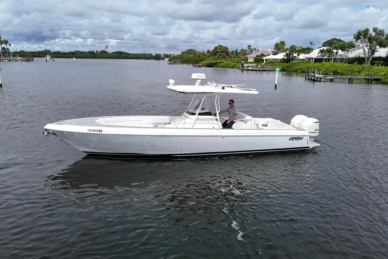  Yacht Photos Pics 2011 Intrepid 323 Cuddy boat on calm water, with a person at the helm.