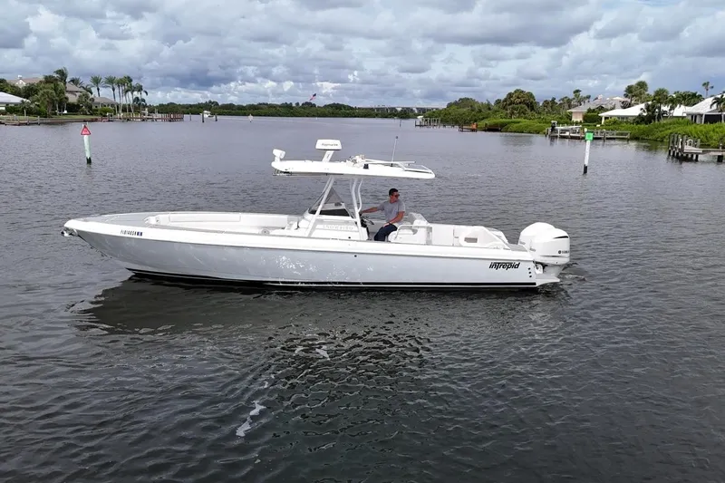  Yacht Photos Pics 2011 Intrepid 323 Cuddy boat on calm water under cloudy sky.