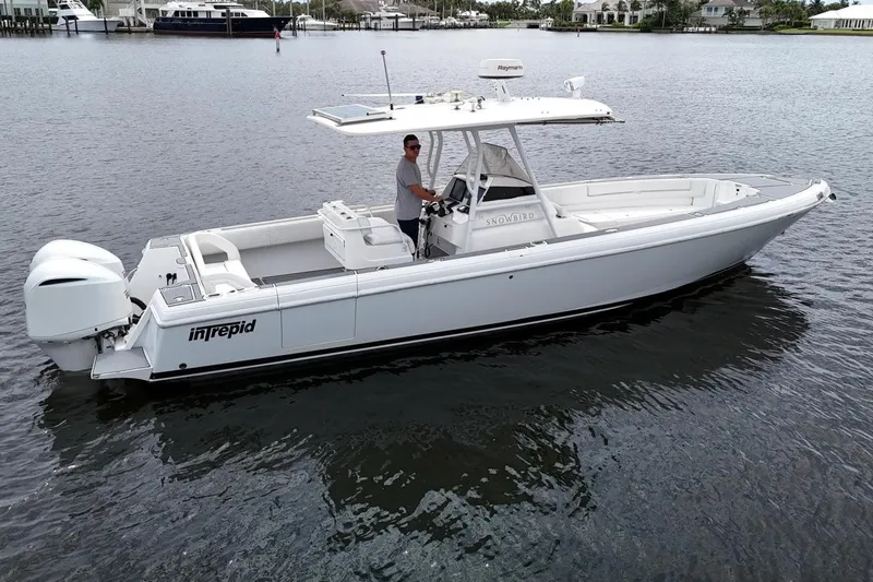 Yacht Photos Pics 2011 Intrepid 323 Cuddy boat on calm water, featuring twin engines and sleek design.