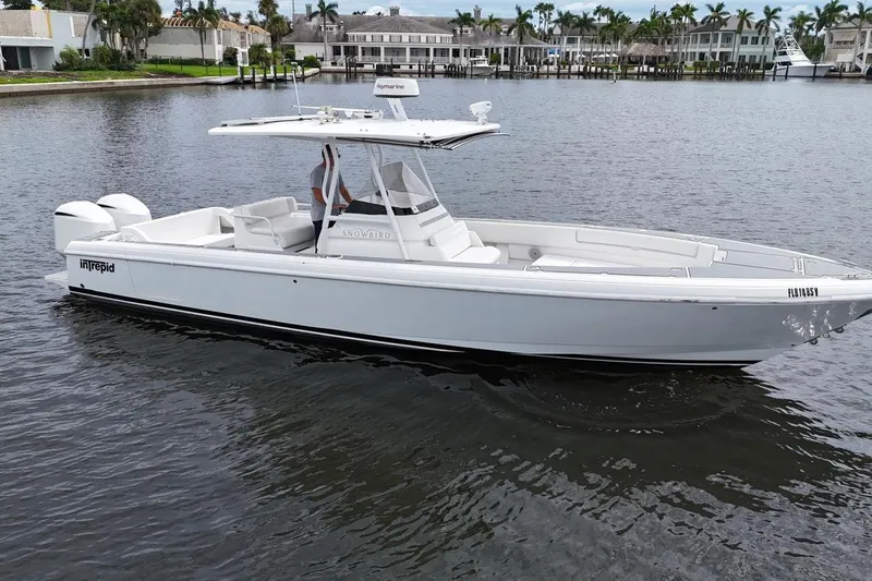  Yacht Photos Pics 2011 Intrepid 323 Cuddy boat on calm water, featuring sleek design and twin engines.