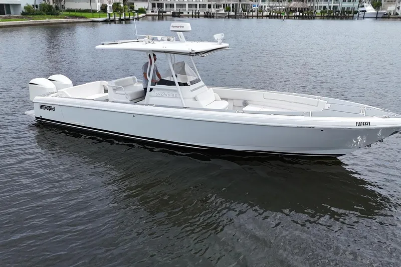  Yacht Photos Pics 2011 Intrepid 323 Cuddy boat on calm water, featuring sleek design and twin engines.