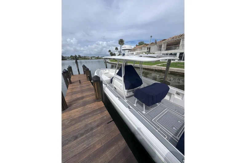  Yacht Photos Pics 2011 Intrepid 323 Cuddy docked by a wooden pier under a cloudy sky.