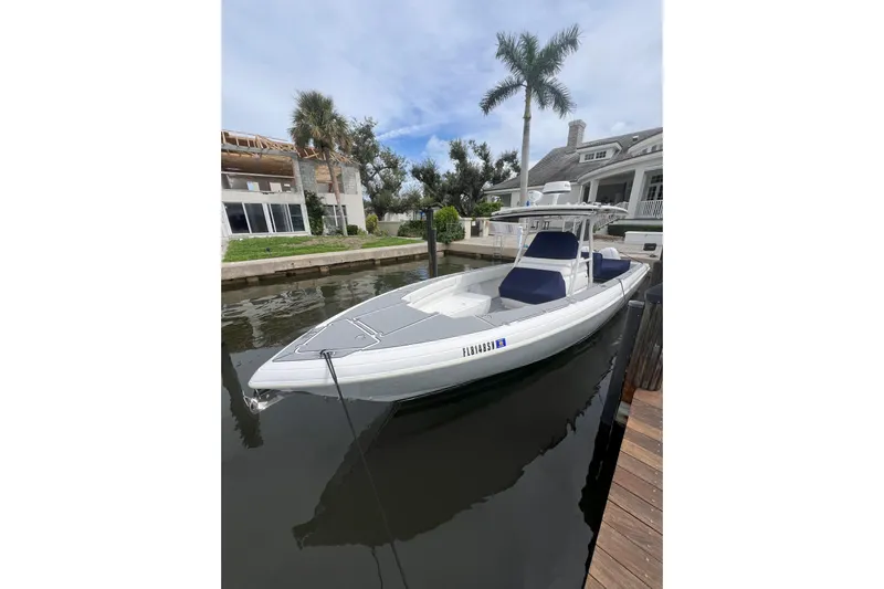  Yacht Photos Pics 2011 Intrepid 323 Cuddy boat docked by waterfront home, under clear sky.