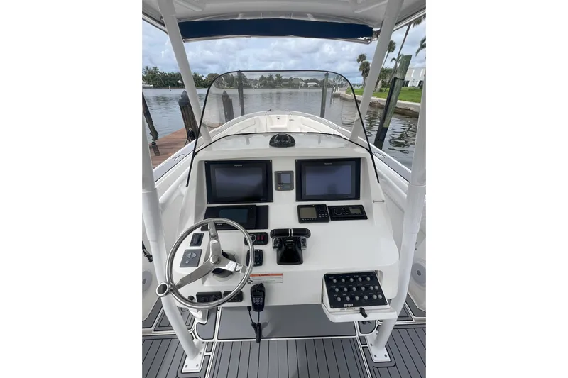  Yacht Photos Pics 2011 Intrepid 323 Cuddy boat helm with modern navigation equipment and steering wheel.