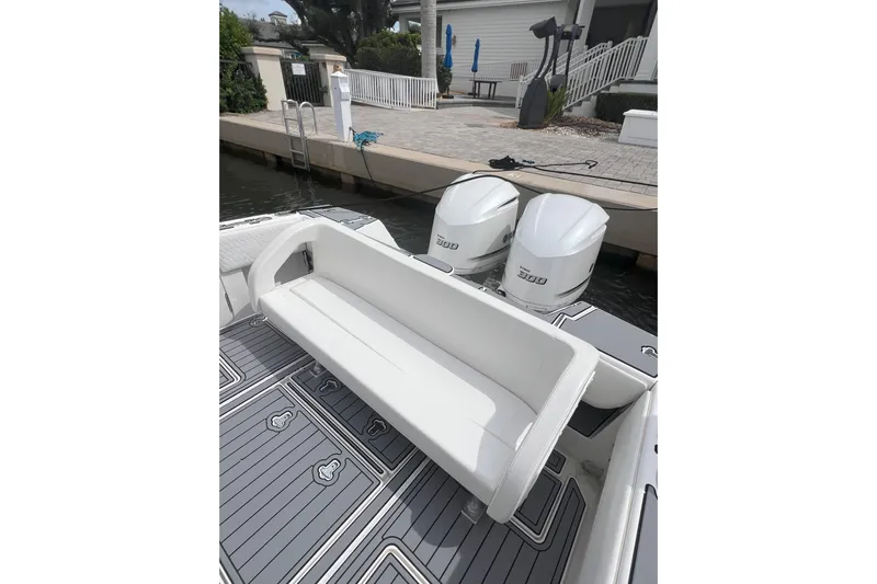  Yacht Photos Pics 2011 Intrepid 323 Cuddy boat with twin engines and cushioned seating at dock.