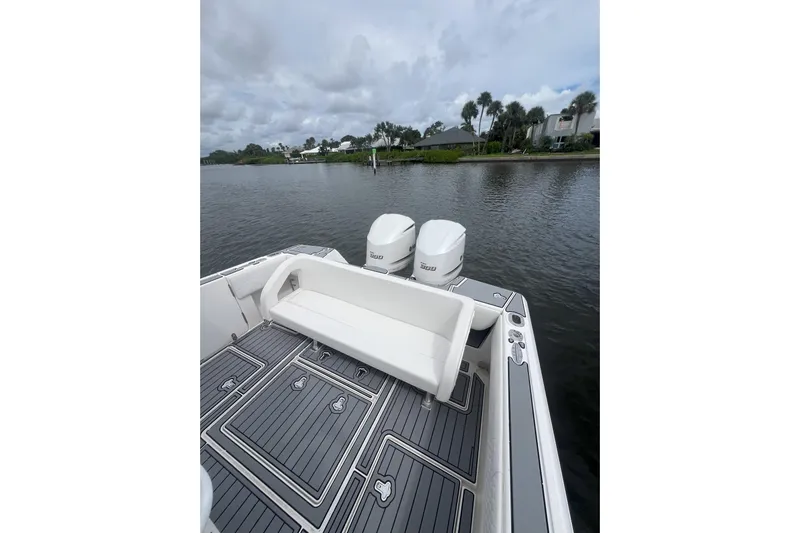 Yacht Photos Pics 2011 Intrepid 323 Cuddy boat with twin engines, docked on a calm river.