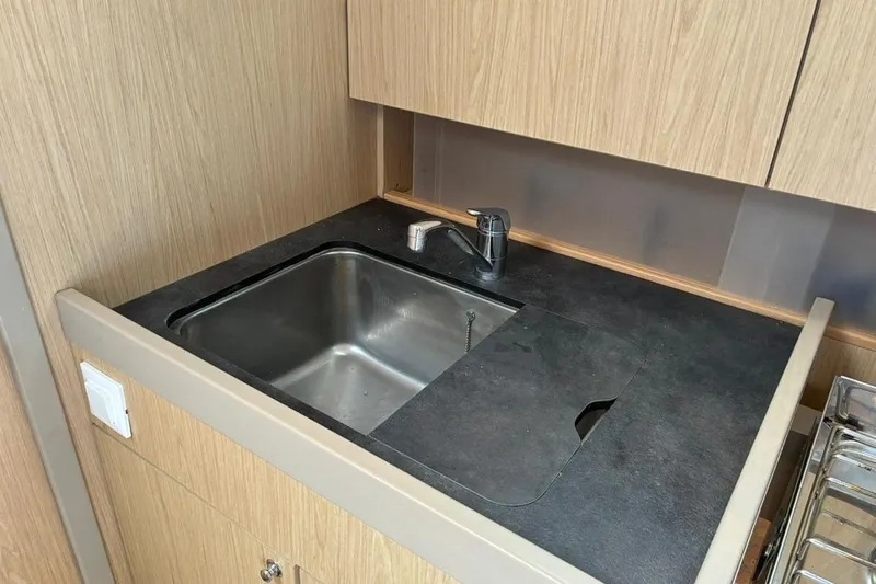 Mar III Yacht Photos Pics Modern kitchen sink in 2020 Beneteau Oceanis 41.1 yacht, featuring sleek design and wood cabinetry.