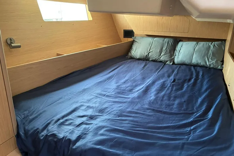 Mar III Yacht Photos Pics Cozy cabin interior of 2020 Beneteau Oceanis 41.1 with blue bedding and wooden finish.