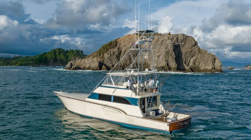 Crushing It Yacht Photos Pics 1996 Donzi 72 Custom Convertible yacht cruising near rocky island.