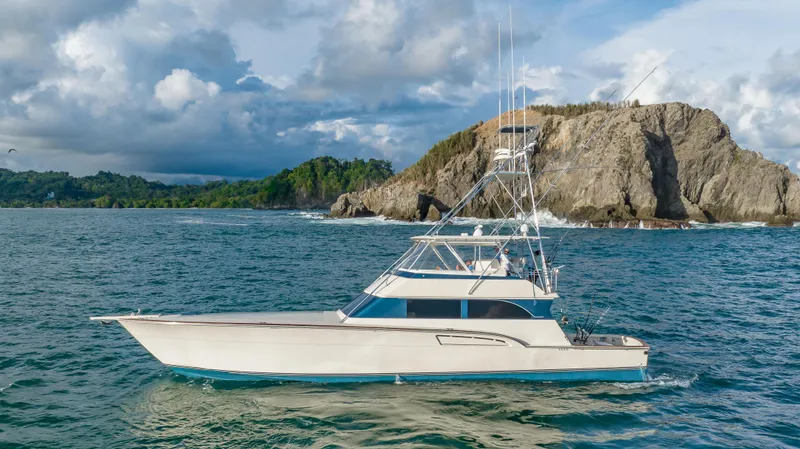 Crushing It Yacht Photos Pics 1996 Donzi 72 Custom Convertible yacht cruising near rocky coastline.