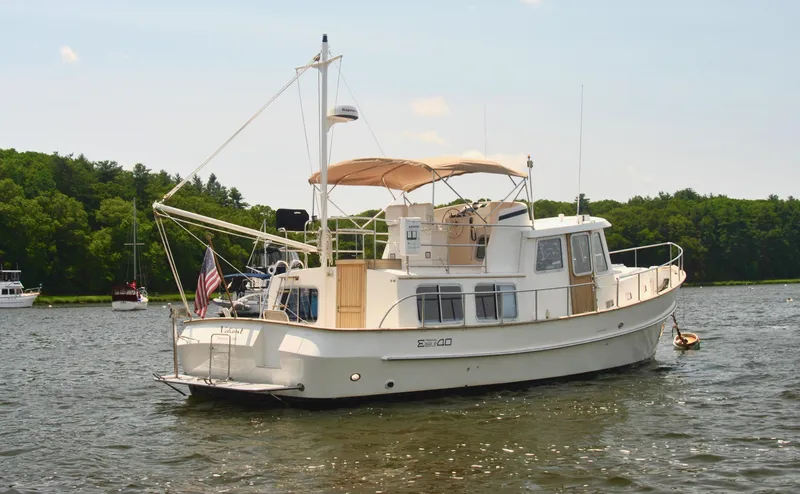 Valiant Yacht Photos Pics 2004 Transpacific Marine Eagle 40 boat on a calm lake with trees in the background.