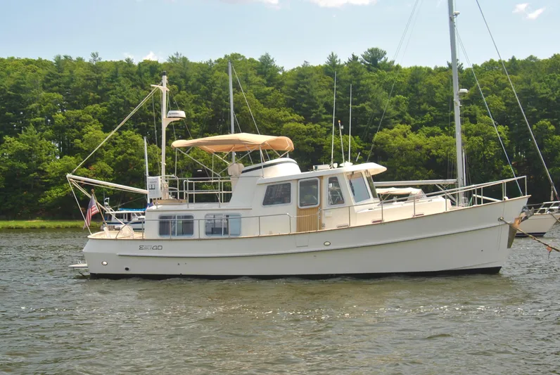Valiant Yacht Photos Pics 2004 Transpacific Marine Eagle 40 yacht on calm water, surrounded by lush greenery.