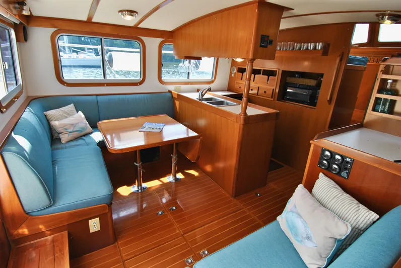 Valiant Yacht Photos Pics Interior of 2004 Transpacific Marine Eagle 40 yacht with cozy seating and wooden finishes.