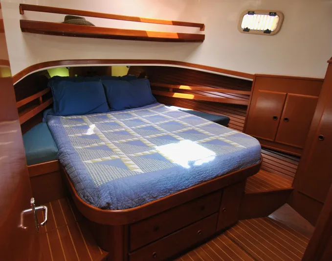 Valiant Yacht Photos Pics Cozy cabin interior of 2004 Transpacific Marine Eagle 40 with wooden finish and bed.