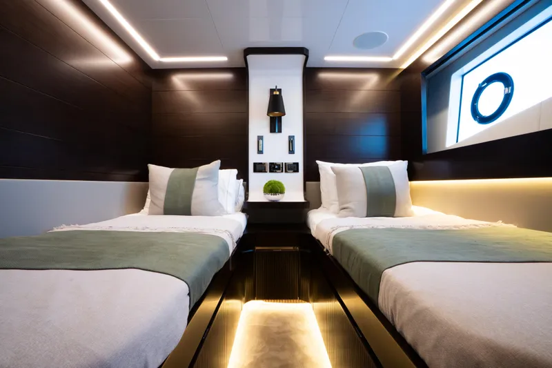 Masie Yacht Photos Pics Luxurious 2023 Pearl 62 yacht cabin with twin beds, modern lighting, and elegant decor.