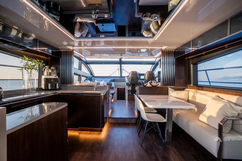 Masie Yacht Photos Pics Luxurious interior of 2023 Pearl 62 yacht with modern kitchen and seating area.