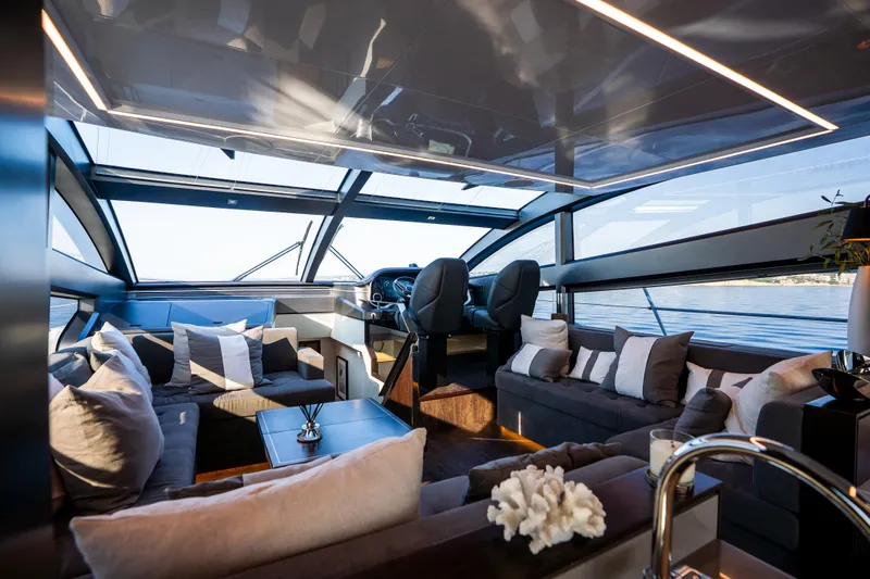 Masie Yacht Photos Pics Luxurious interior of 2023 Pearl 62 yacht with panoramic windows and plush seating.