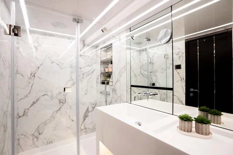 Masie Yacht Photos Pics Luxurious modern bathroom with marble walls, glass shower, and sleek fixtures in a Pearl 62 yacht, 2023.