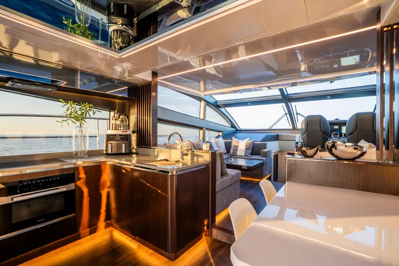 Masie Yacht Photos Pics Luxurious interior of 2023 Pearl 62 yacht with modern kitchen and seating area.