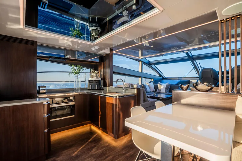 Masie Yacht Photos Pics Luxurious interior of 2023 Pearl 62 yacht with modern kitchen and seating area.