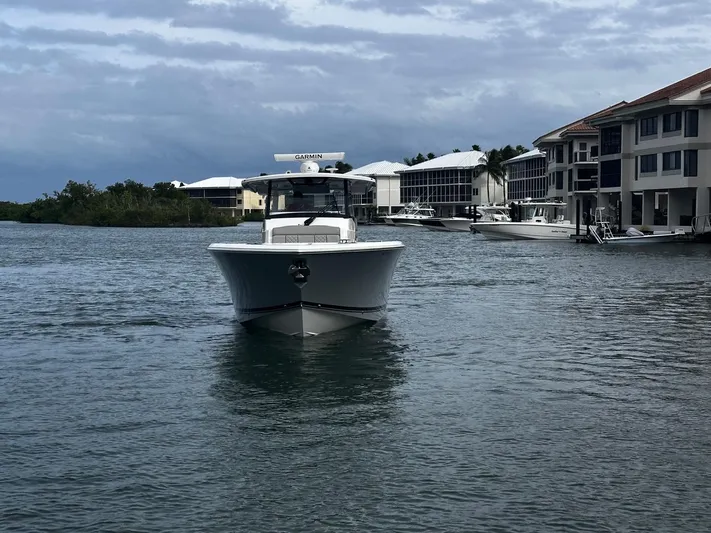  Yacht Photos Pics 2024 Pursuit 358 SPORT boat on water near waterfront homes.